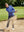 Model swinging on golf course wearing full print lightweight quarter zip pullover in cobalt wave
