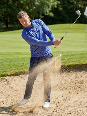 Model swinging on golf course wearing full print lightweight quarter zip pullover in cobalt wave