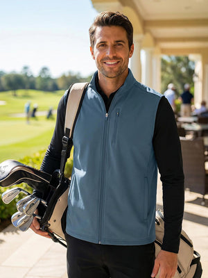 Half-body shot of a model wearing a misty blue sleeveless softshell fleece outdoor vest with 6 pockets