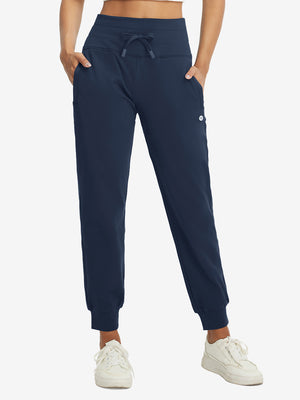 Model wearing women's stretch fleece lined water resistant joggers in navy, showcasing the front lower body view.
