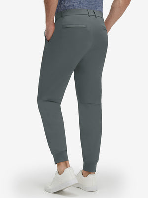 Back lower body shot of model wearing dark grey flat front golf joggers pants with belt loops