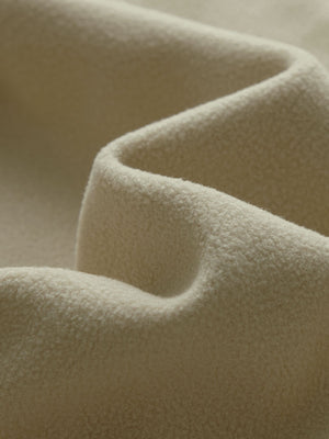 Close-up fabric detail of golf fleece winter puffer jackets, quilted texture and warm feel in light khaki