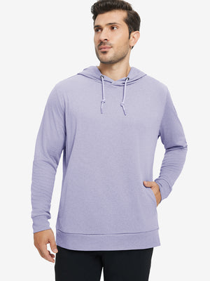 Model with one hand in pocket, wearing classic heather pullover hoodie in light purple melange, relaxed look.