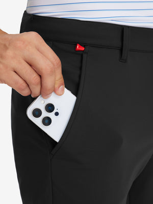 Side pocket detail of Golf Lightweight Fleece Lined Dress Pants in black, holding smartphone