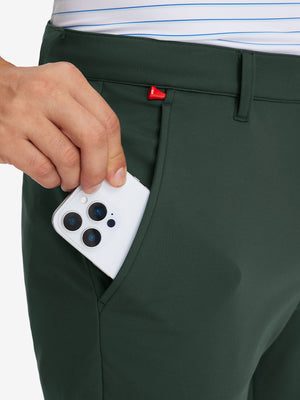 Side pocket detail of Golf Lightweight Fleece Lined Dress Pants in forest green, holding smartphone