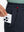 Close-up detail showing phone being placed in the pocket of navy thermal water repellent fleece dress pants