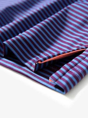 Close-up of side hem slit on PLUM BLUE STRIPE polo, detailing for comfort and mobility