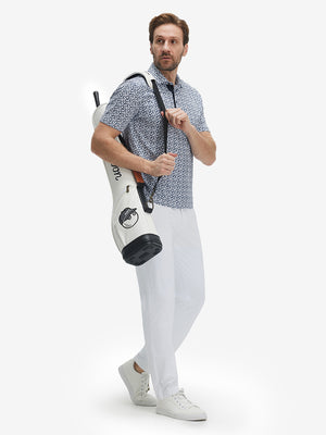 Model carrying tennis bag in Performance quick dry print golf polos, white navy clouds