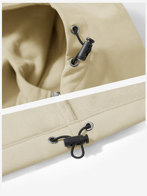 Close-up of zipper and button details on reflective hooded softshell jacket in light khaki.