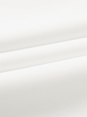Close-up of wrinkle-resistant, sun-protective fabric on water-resistant golf stretch nylon pants in white.