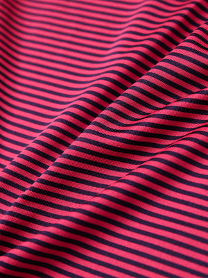 Texture close-up of Kids stripe golf polos with soft fabric and bright red stripe stripes