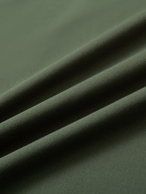 Close-up of olive green long sleeve solid jersey polo fabric texture showing soft knit and smooth finish details.