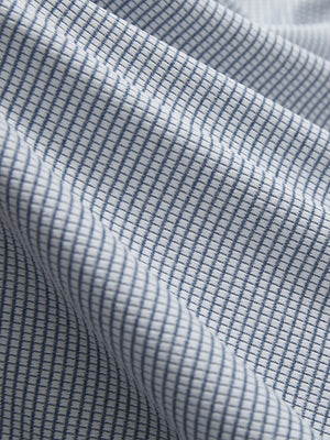 Close-up texture of white light blue grid featherweight midlayer quarter zip pullover fabric showing detailed lightweight material and weave.