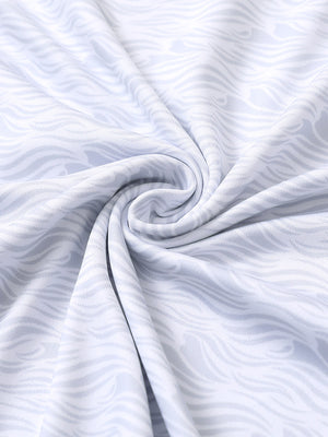 Close-up of white grey sea wave performance jersey print polo fabric showing breathable texture and vibrant pattern details.