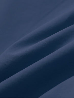 Close-up of dark blue boys lightweight dry fit flat front golf shorts fabric texture.