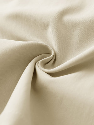 Close-up fabric detail of 4-way stretch performance solid shorts, smooth texture with flexible light khaki feel