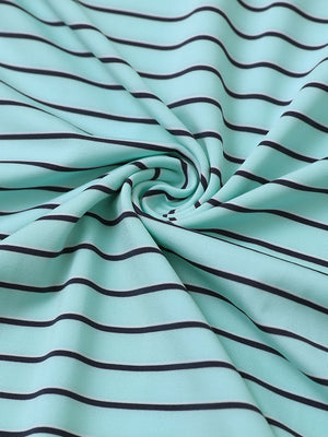 Close-up fabric view of youth performance golf polos, smooth texture with breathable turquoise/navy stripe finish