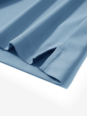 Close-up of the hem vent on the misty blue ventilated pique performance polo, showing the side split for movement