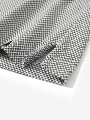 Detail shot of the hem vent on the black quick dry jacquard ribbed collar golf shirt