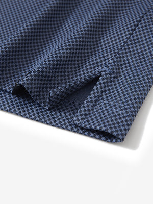 Detail shot of the hem vent on the blue quick dry jacquard ribbed collar golf shirt