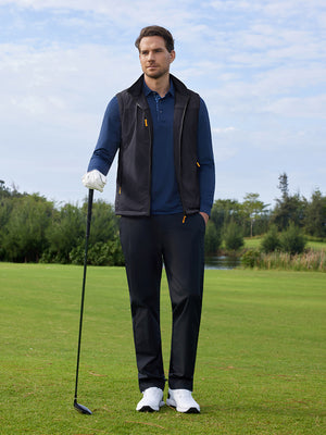 A model holding a golf club is photographed in a full-body shot, wearing a black windproof fleece reversible golf vest.