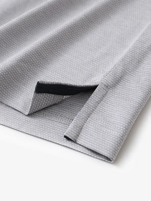 Close-up of side hem slit on Ventilated Heather Jacquard Polo in FADED DENIM HEATHER, showing detail