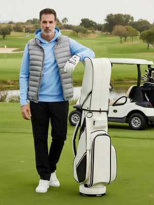 Model leaning on a golf bag on course, wearing dry fit stretchy sweatshirts hoodies in relaxed light blue style