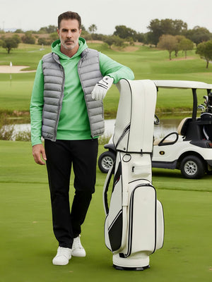 Model leaning on a golf bag on course, wearing dry fit stretchy sweatshirts hoodies in relaxed light green style