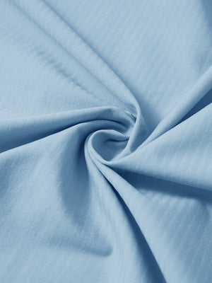 Close-up fabric detail of lightweight water-resistant outerwear jacket, smooth light blue texture