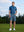 Model standing on course with one hand in pocket, wearing 4-way stretch performance solid shorts in grayish blue